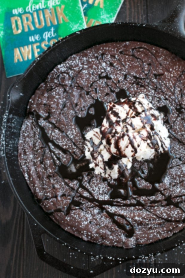 Serving a Whiskey Skillet Brownie straight from the skillet with a spoon