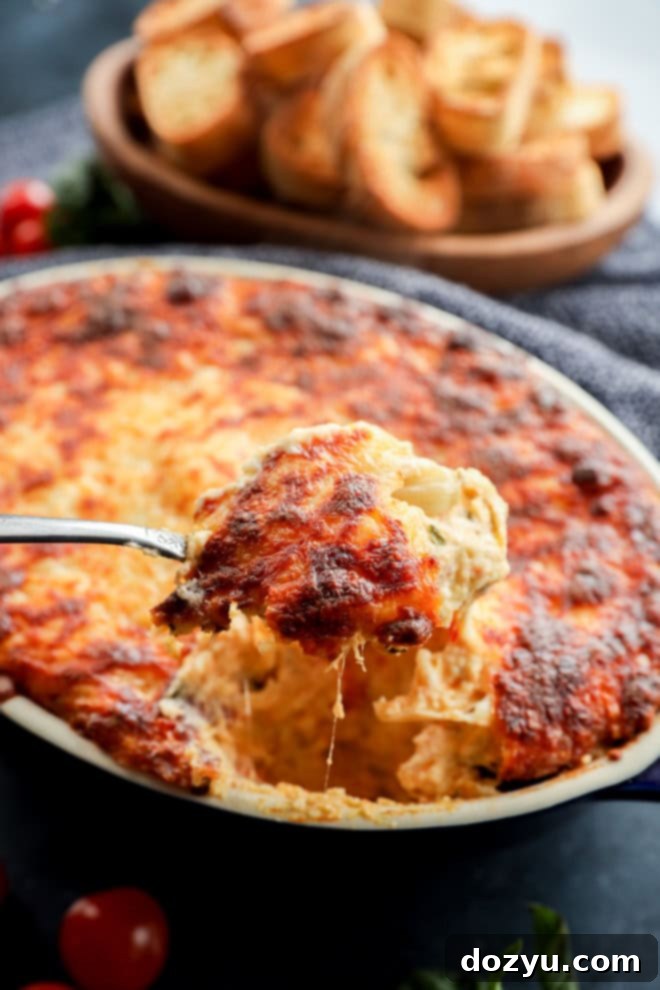 spoon lifting out cheesy four cheese pizza dip