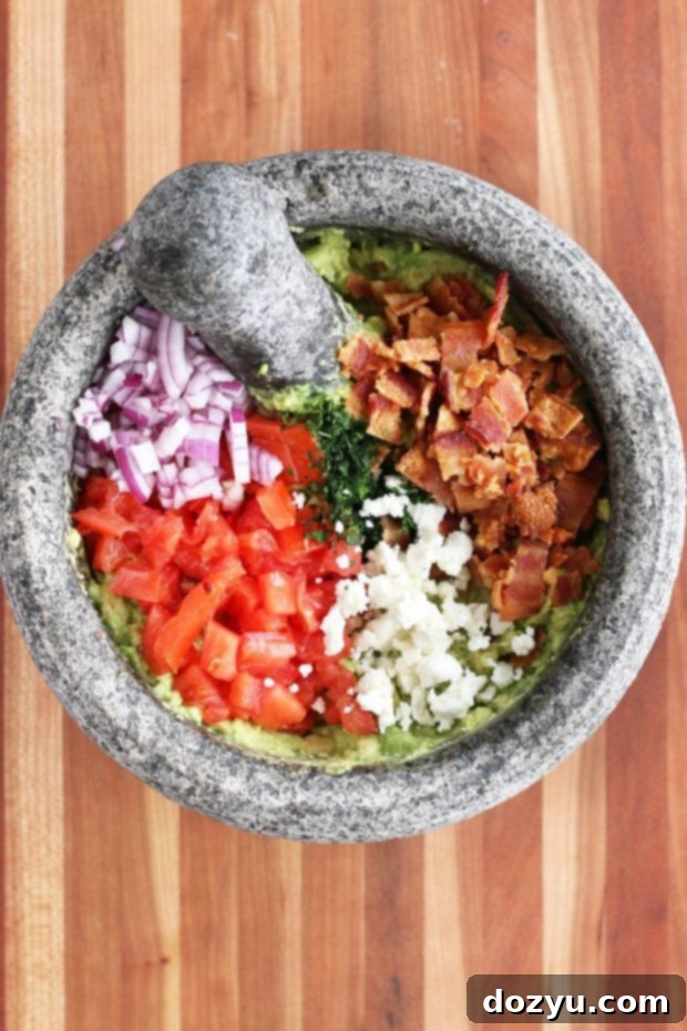 BLT Guacamole served with tortilla chips, inviting a delicious scoop.