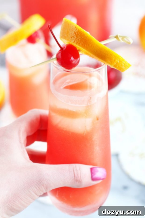 Hand holding champagne flute with cocktail image