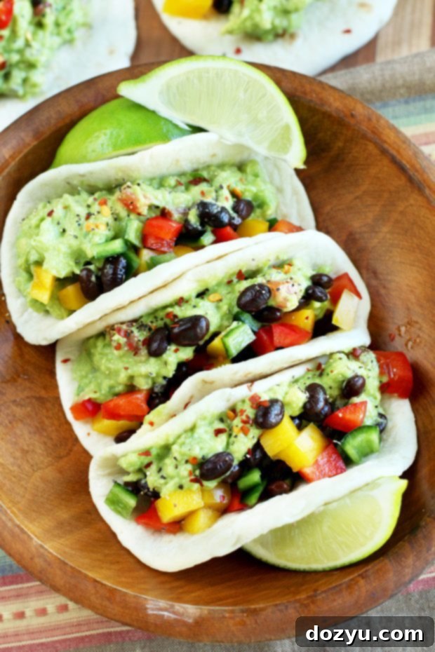 Hands holding a beautifully assembled guacamole taco