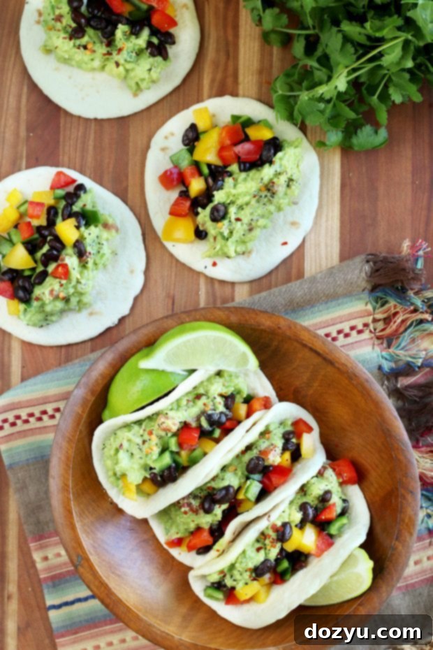 A vibrant guacamole taco plate with lime, cilantro, and hot sauce