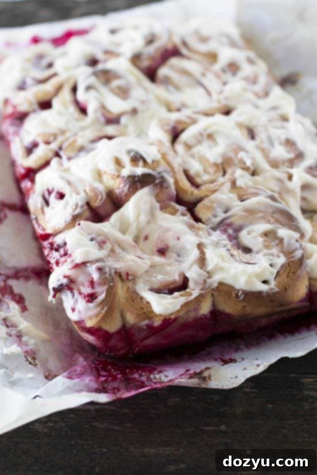 Zesty Raspberry Lemon Rolls with Silky Cream Cheese Frosting 2 Overhead shot of raspberry lemon sweet buns with cream cheese frosting on a serving plate.