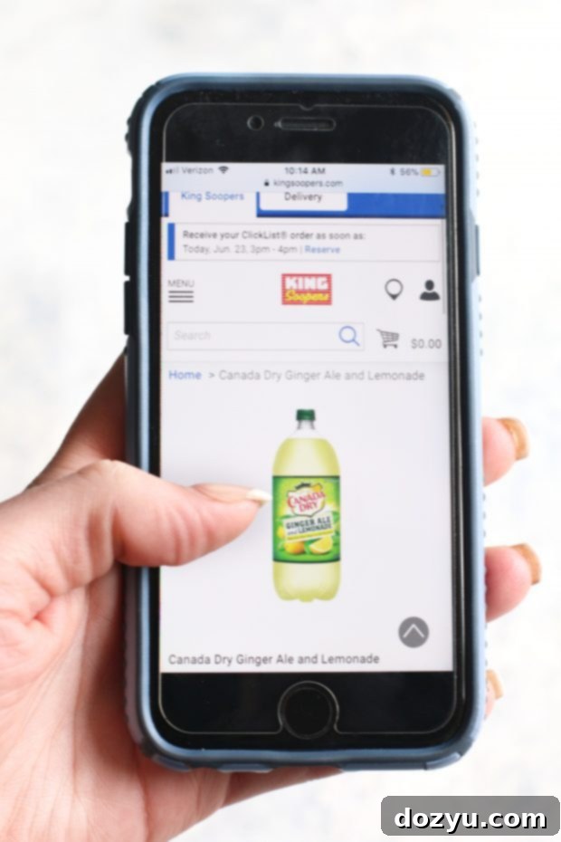 A full glass of Mixed Berry Ginger Lemonade Frozen Mocktail with a straw and garnish.