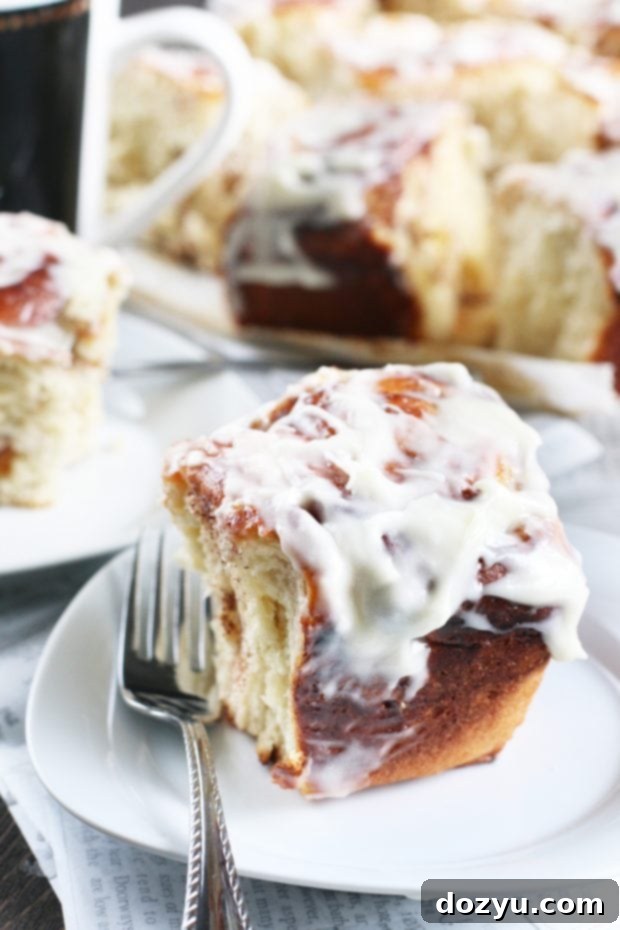 Luscious Bourbon Peach Cinnamon Rolls 7 Close-up of a Bourbon Peach Cinnamon Roll being pulled apart, revealing the juicy peach filling