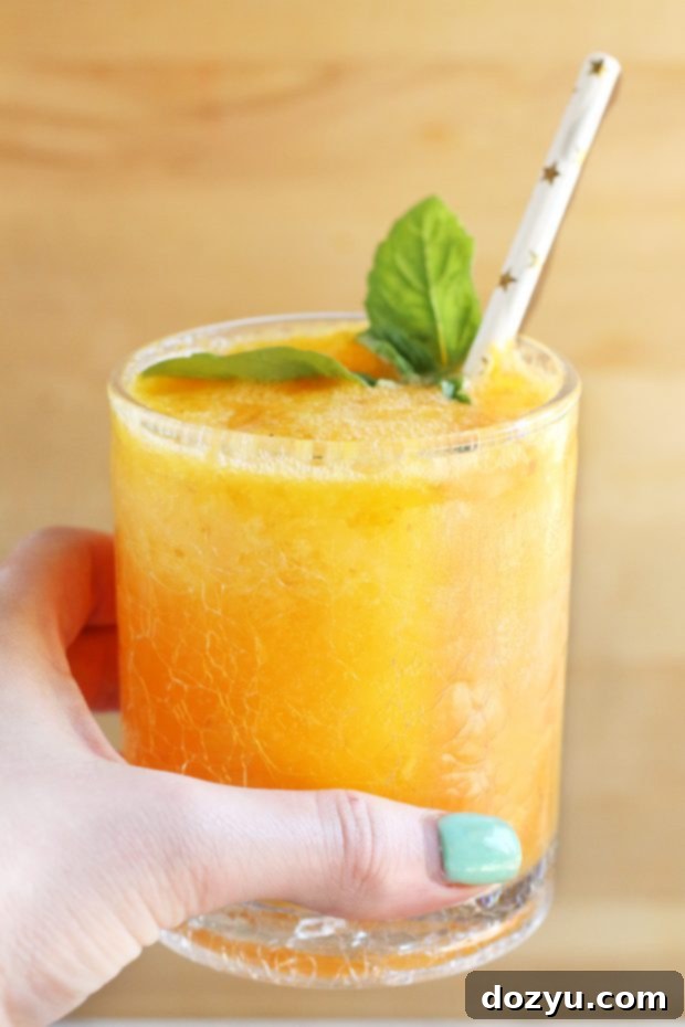 Caramelized Peach Gin Fizz 4 Close-up of a Roasted Peach Gin Fizz cocktail garnished with basil