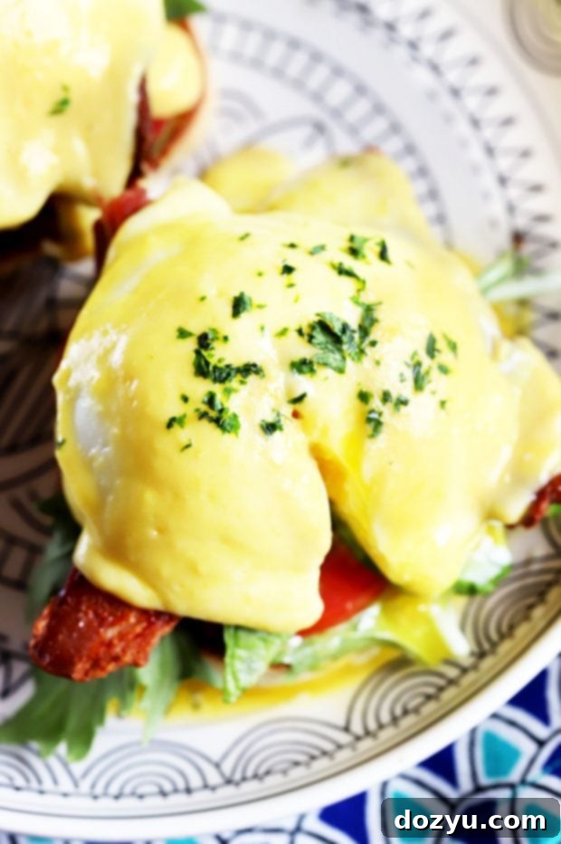 Close-up of a BLAT Eggs Benedict, highlighting the crispy bacon and fresh avocado.