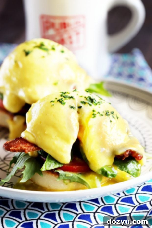 A close-up of a BLAT Eggs Benedict, showing the rich, runny yolk spilling over the fresh ingredients.