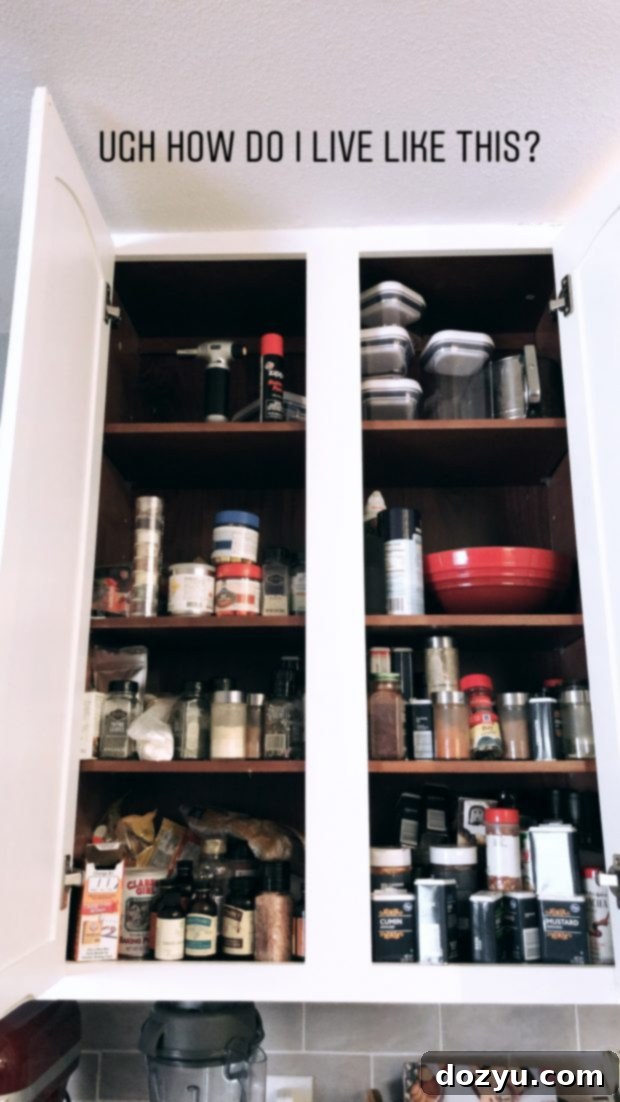 Messy spice cabinet before organization, with many jars in disarray