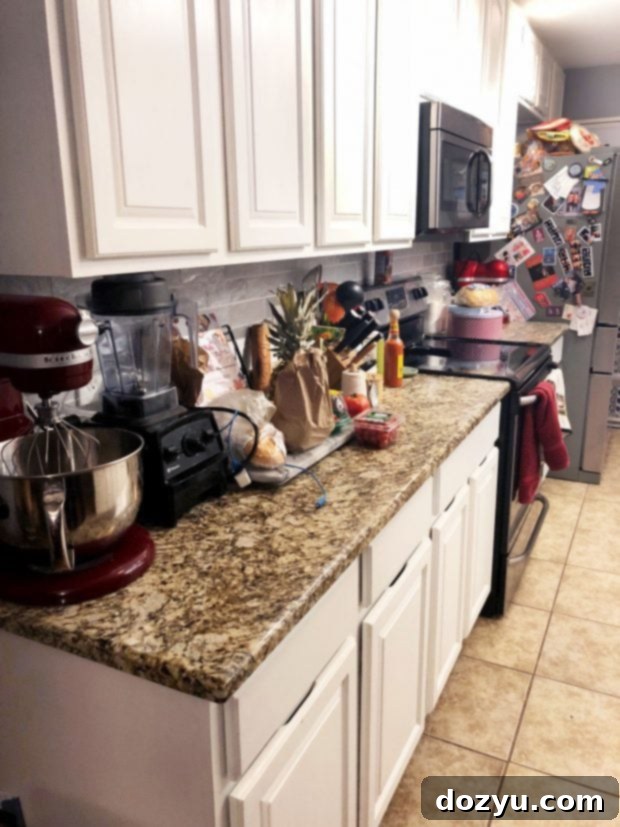 Cluttered kitchen counters and surfaces before organization, showing appliances and miscellaneous items