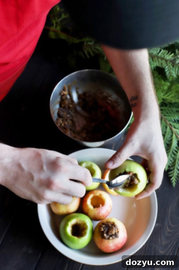 A dish of Stuffed Baked Apples with a spoon, highlighting the gooey filling