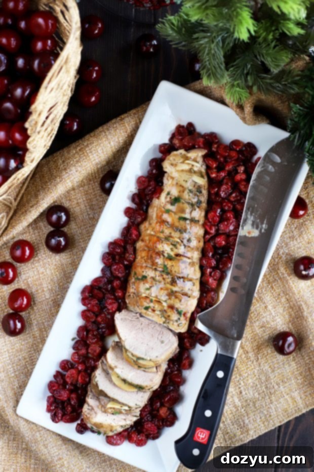 Close-up of the hasselback pork tenderloin being prepared with cranberries