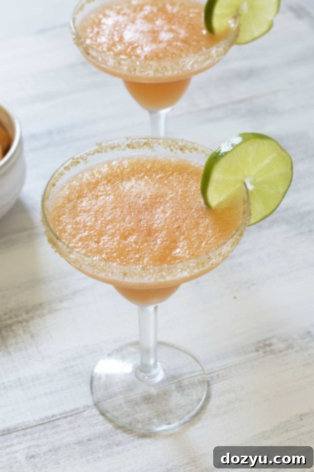 Melon Margarita Frost 2 Frozen Melon Margarita in a glass with a lime garnish.