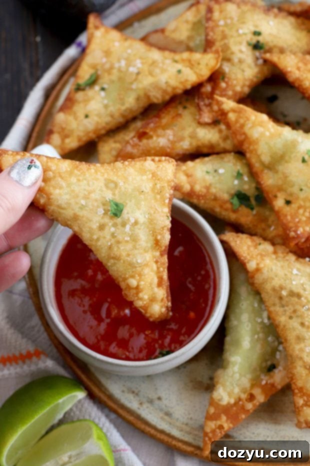 Closeup of a hand holding a Guacamole Wonton