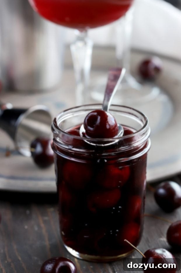 A finished Manhattan cocktail garnished with homemade brandy cherries