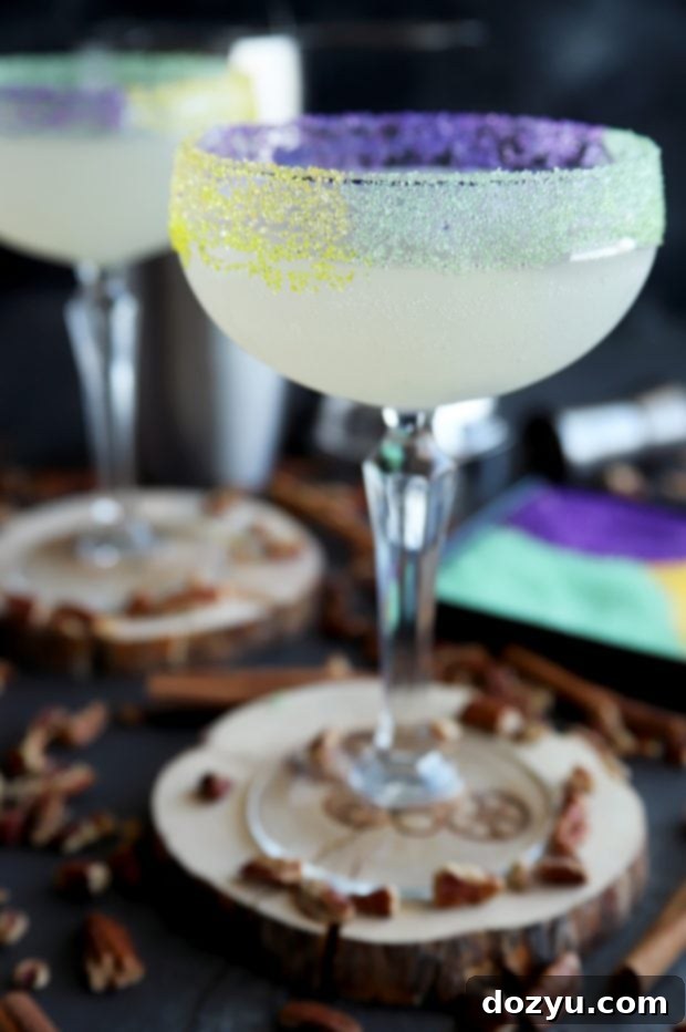 Pouring a King Cake Daiquiri into a festive rimmed glass, ready to be served.