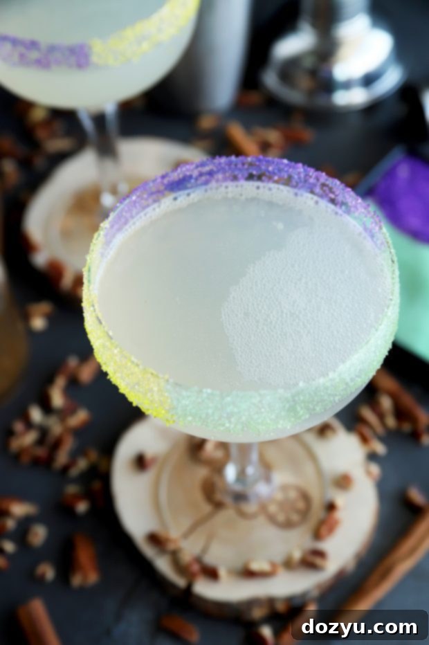 A vibrant King Cake Daiquiri with a multi-colored sugar rim, garnished and ready for a festive occasion.