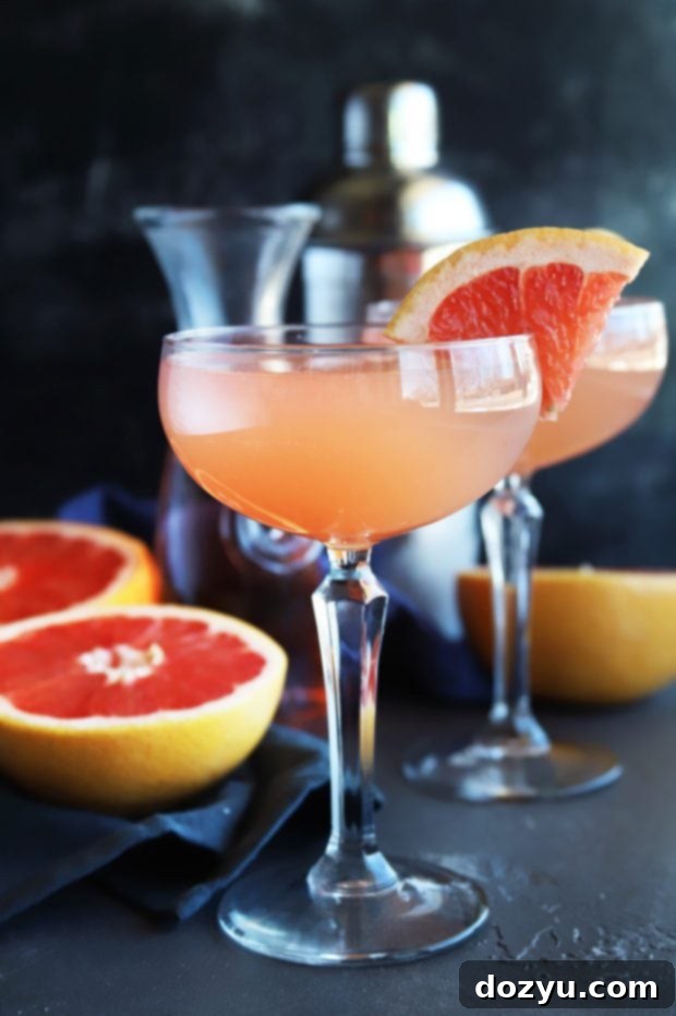 Rosé Grapefruit Sparkler 2 A vibrant Sparkling Grapefruit Rosé Cocktail in a coupe glass, garnished with a grapefruit slice, perfect for summer sipping.