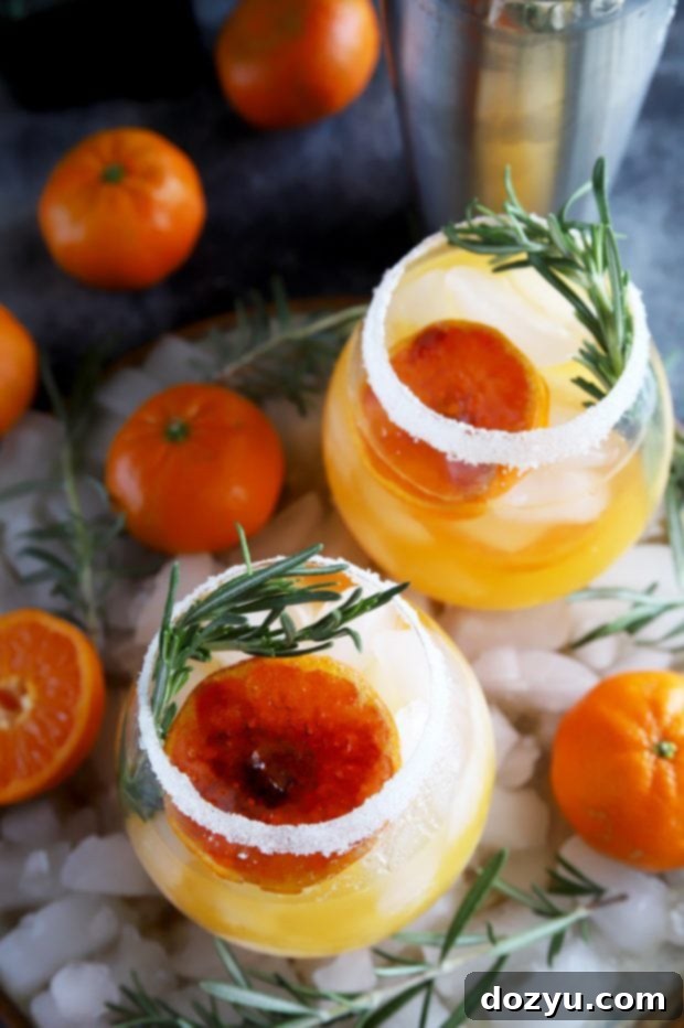 Clementine Mezcal Margarita with a brûléed clementine and rosemary garnish