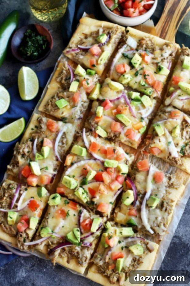 Avocado Pulled Pork Flatbread sliced and ready to serve, featuring creamy avocado and colorful pico de gallo.