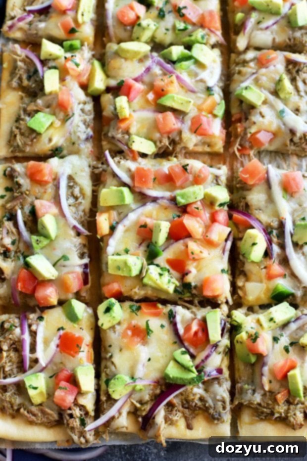 A vibrant slice of Avocado Pulled Pork Flatbread with grilled tomatillo salsa, ready to be enjoyed.