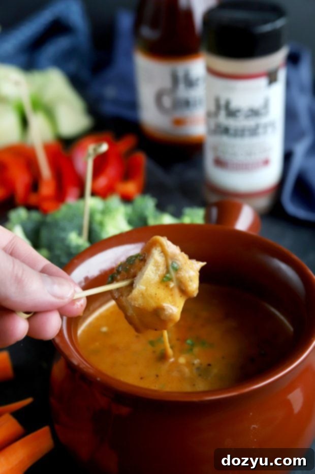 Chipotle Fondue Short Ribs 3 Bread dipping into rich and creamy short rib BBQ fondue, highlighting the perfect texture and delicious blend of flavors.