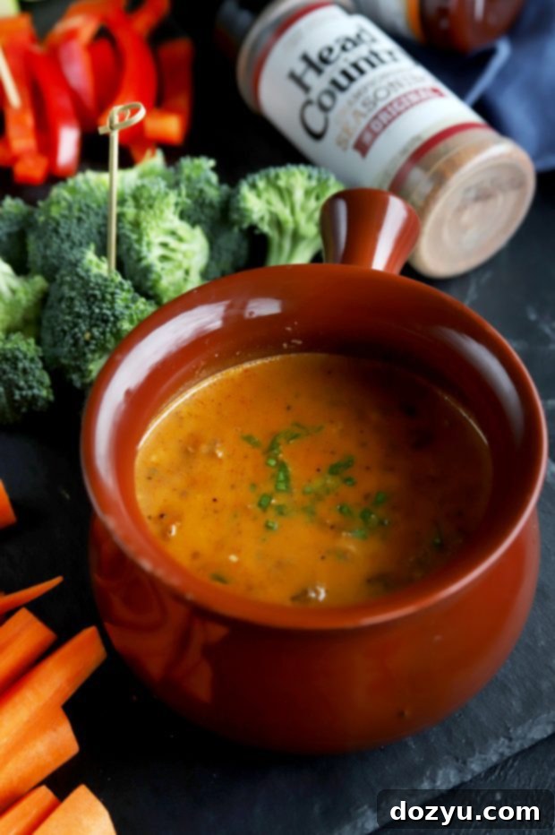 Chipotle Fondue Short Ribs 4 Rich and creamy BBQ Short Ribs Fondue in a bowl, surrounded by various dippers, ready for a gathering.