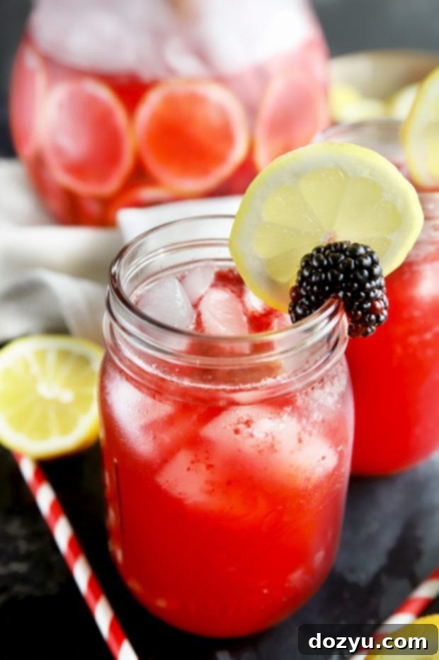 Summer cocktail served in charming mason jars with fresh berries and lemon slices, perfect for outdoor entertaining