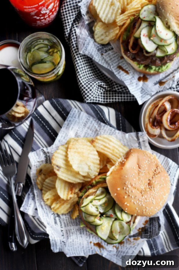 Two gourmet Miso Glazed Sriracha Burgers, freshly grilled and ready to be served, showcasing their vibrant toppings and toasted buns.