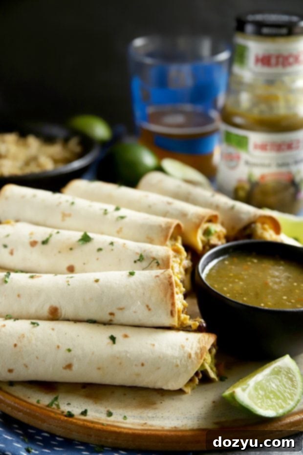 A vibrant platter of crispy baked taquitos, garnished with fresh cilantro, ready for a gathering