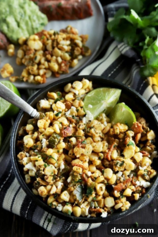 Grilled corn salad in a bowl with limes