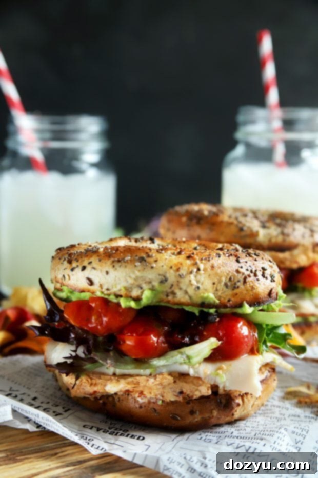 Healthy turkey bagel sandwich with avocado and tomatoes