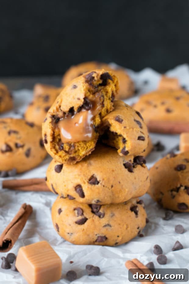 Gooey Caramel Pumpkin Cookies 2 Freshly baked caramel stuffed pumpkin chocolate chip cookies on a cooling rack