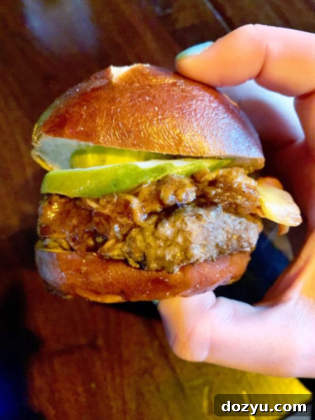 Juicy beef slider topped with slow-cooked pulled pork from Kuma's Corner, a savory delight in Chicago.