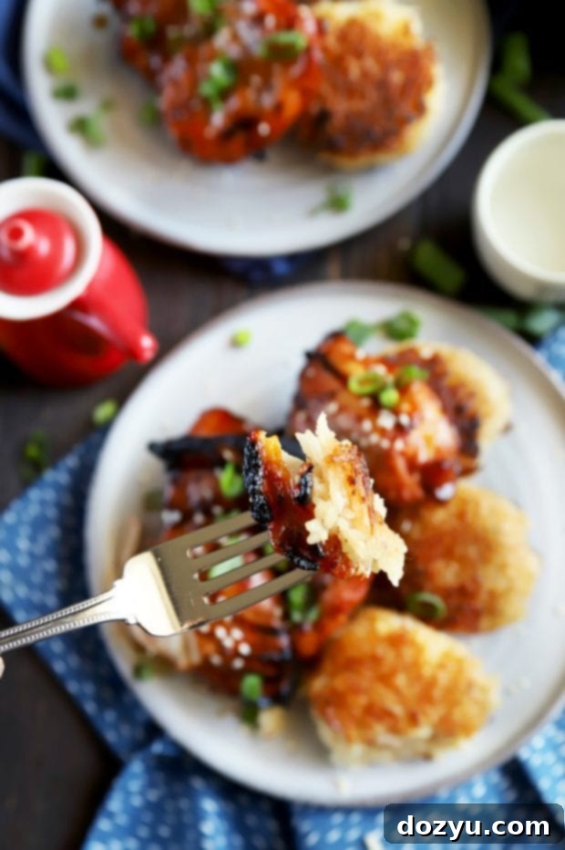 A fork holding a bite of spicy Korean chicken and crispy ginger rice, showing the delicious textures