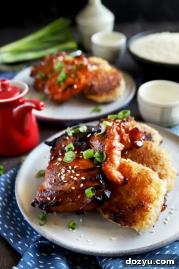 Grilled Korean chicken thighs over crispy ginger rice cakes, garnished with green onions