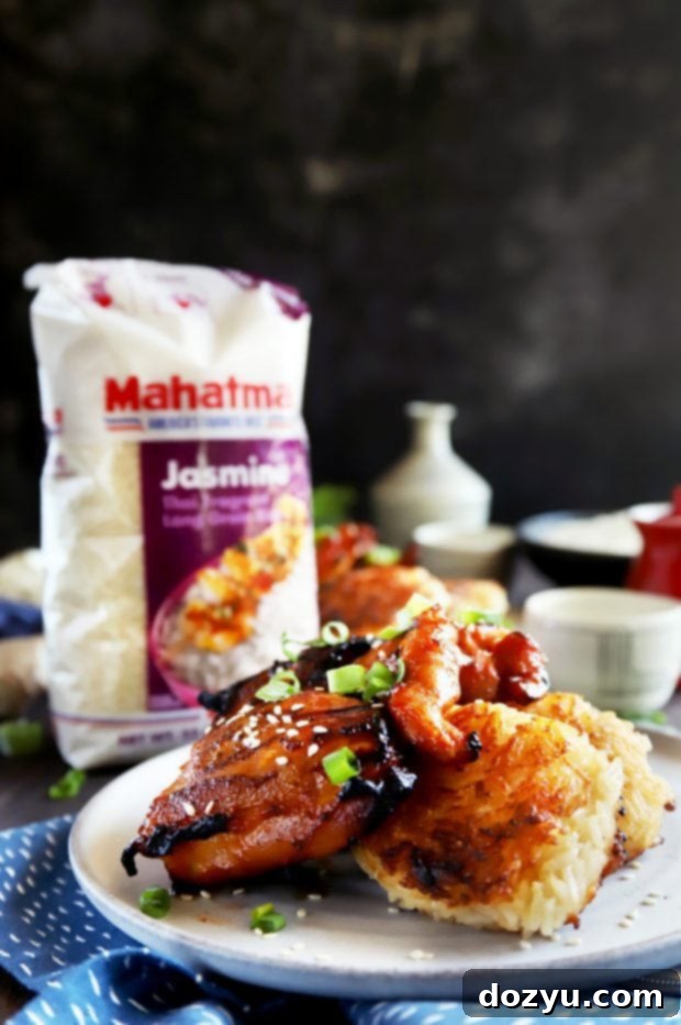 Straight on photo of grilled Korean chicken thighs served atop crispy ginger rice cakes