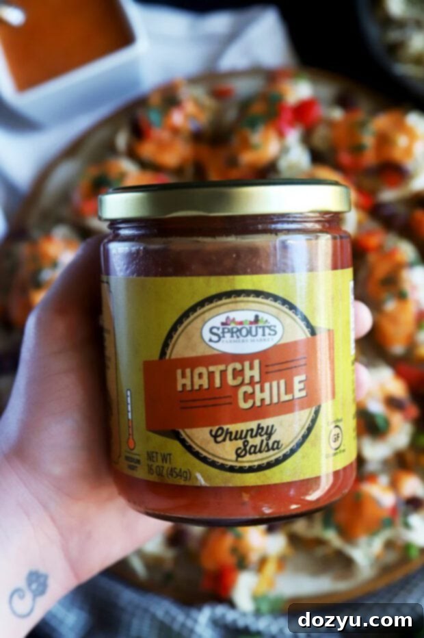 Hatch Green Chile Chicken Nacho Bites 7 A jar of Sprouts Hatch Chile Chunky Salsa (red variety), showcasing its vibrant color and texture