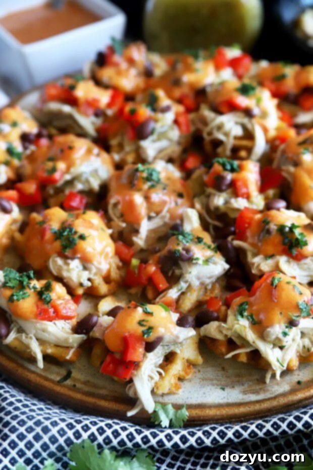 Hatch Green Chile Chicken Nacho Bites 8 Close-up shot of Hatch green chile chicken nachos on waffle fries, beautifully arranged