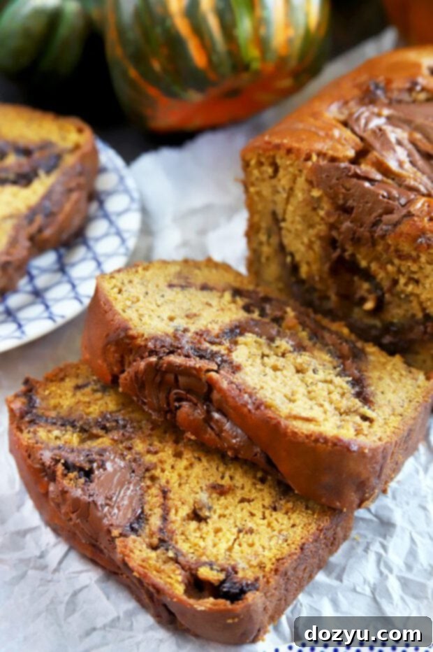 Decadent Pumpkin Banana Bread with Nutella Swirls 8 Multiple slices of freshly baked, golden-brown Pumpkin Banana Bread with distinct Nutella swirls, arranged on a cooling rack.