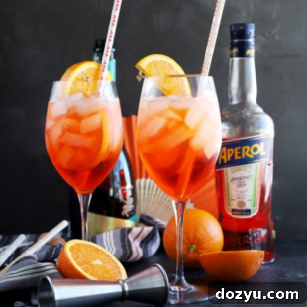 Aperol Spritz cocktail in a large wine glass with ice and an orange slice garnish.