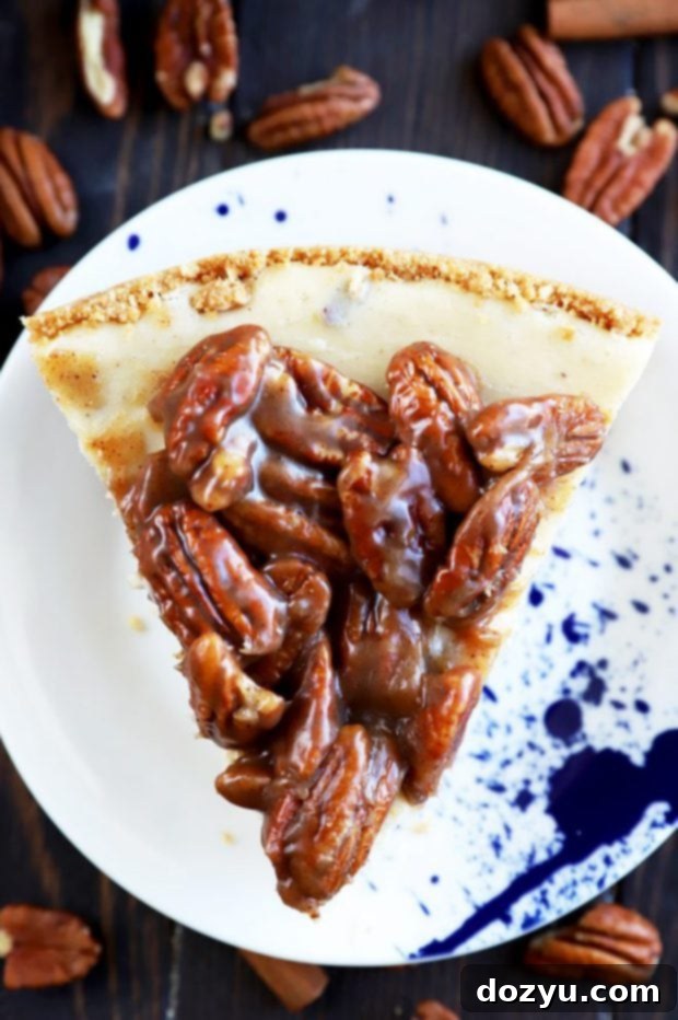 A single slice of pecan pie cheesecake ready for Thanksgiving, showcasing its layers.