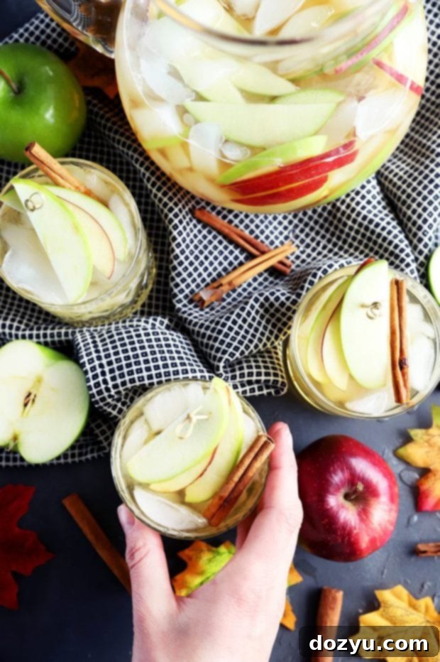 Hand grabbing a glass of white apple pie sangria