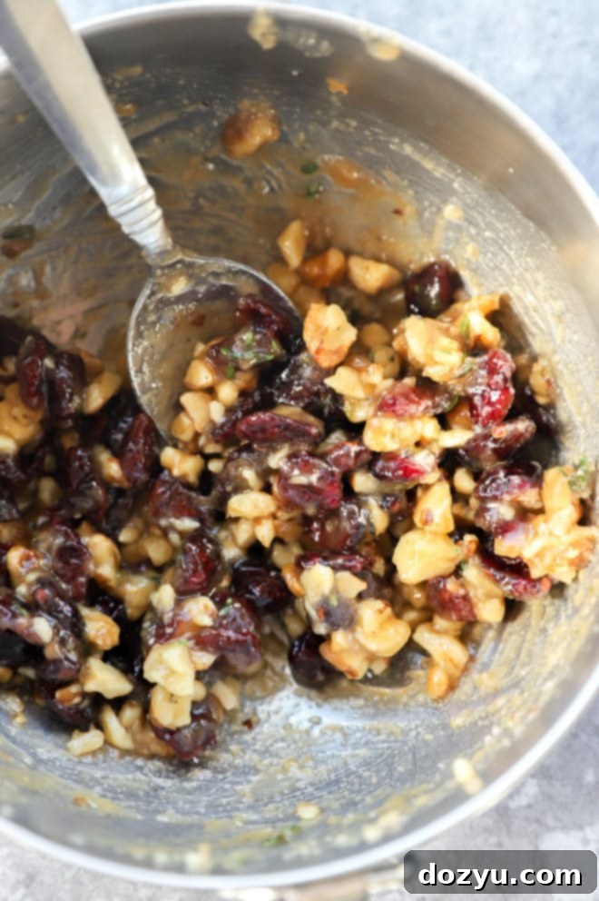 Mixture of butter, cranberries, walnuts, and sugar in a bowl, ready for baked camembert