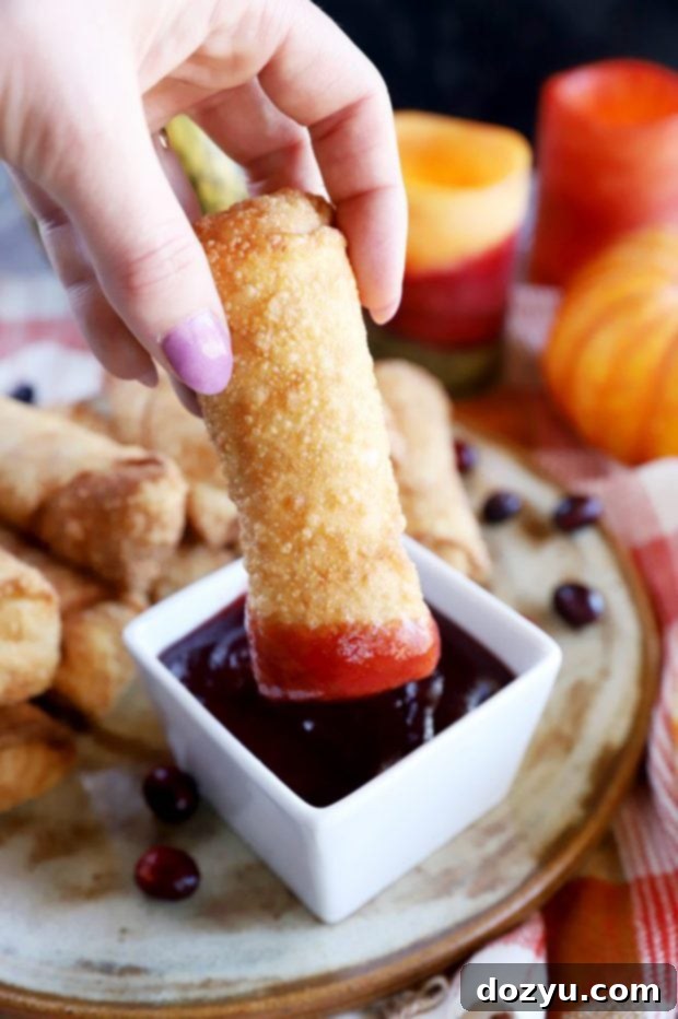 Dipping an egg roll in cranberry sauce image