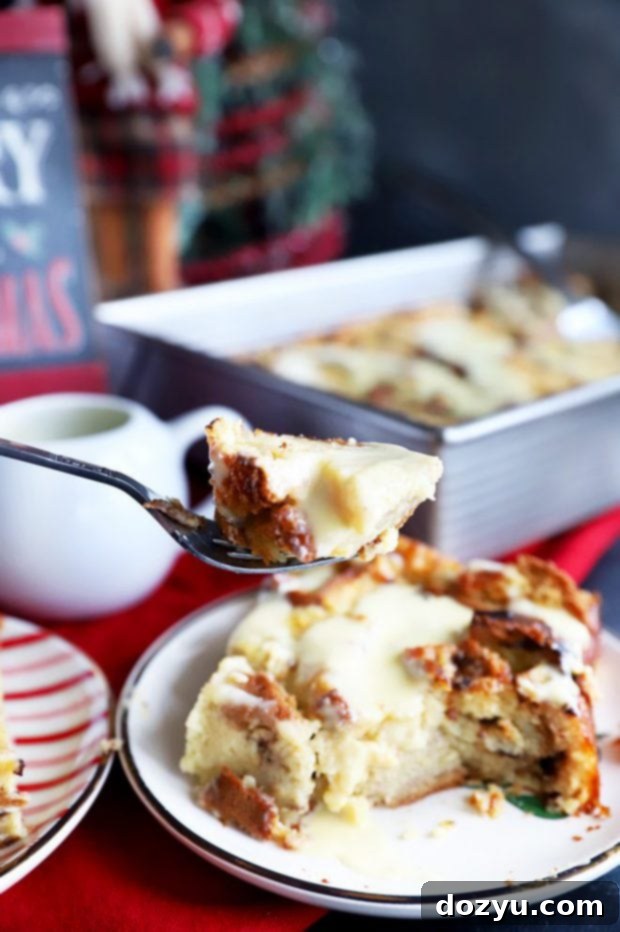 A beautifully presented slice of golden Panettone Bread Pudding, drizzled generously with creamy Crème Anglaise, ready to be enjoyed.