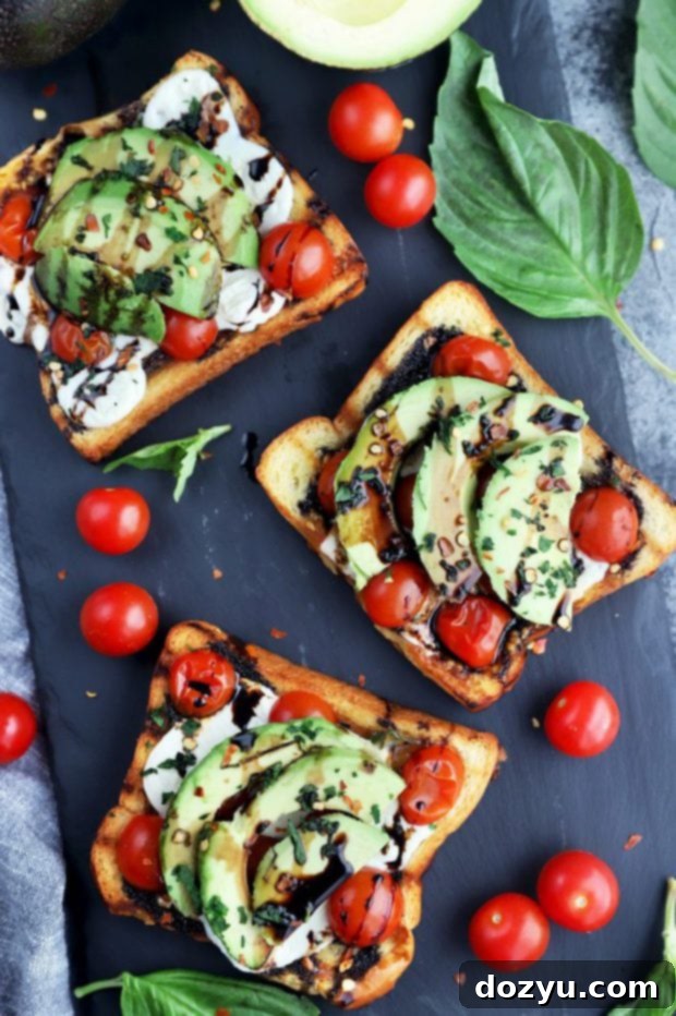 Overhead photo of an inviting Grilled Open-Faced Avocado Caprese Sandwich, showcasing fresh ingredients like tomatoes, mozzarella, basil, and avocado on golden grilled bread, drizzled with balsamic glaze.