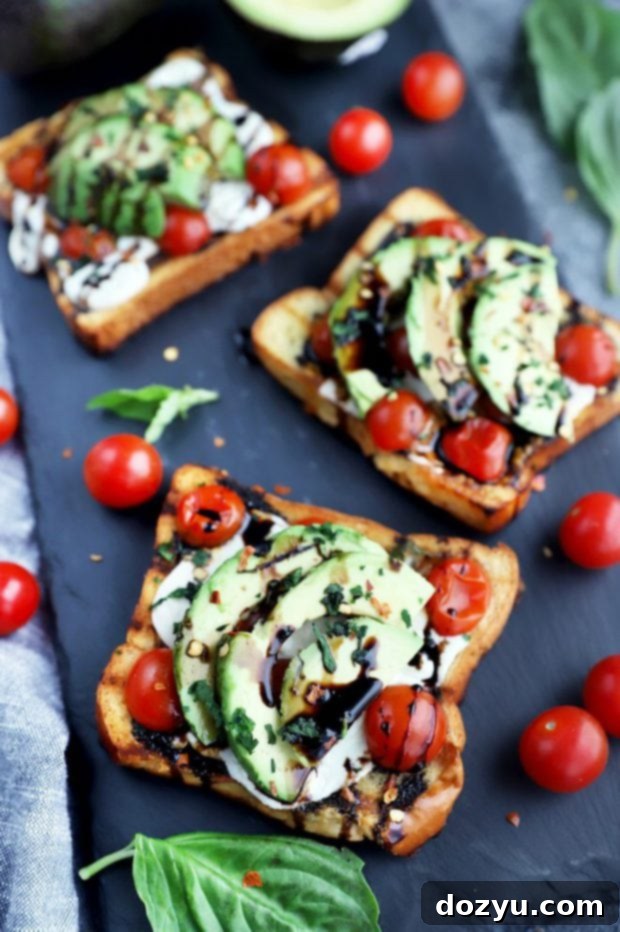 A vibrant display of freshly prepared open-faced Caprese sandwiches, with a focus on the colorful layers of ingredients.