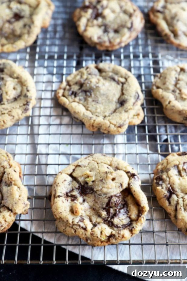 Freshly baked dark chocolate pistachio cookies cooling on a wire rack