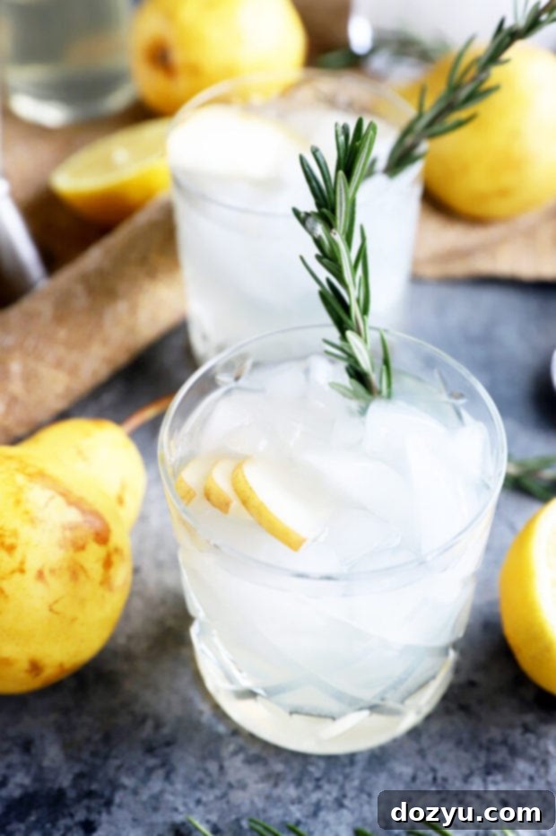 Aromatic Pear Rosemary Gin and Tonic 5 Close-up of a Pear Rosemary Gin and Tonic, showcasing the pear and rosemary garnish.